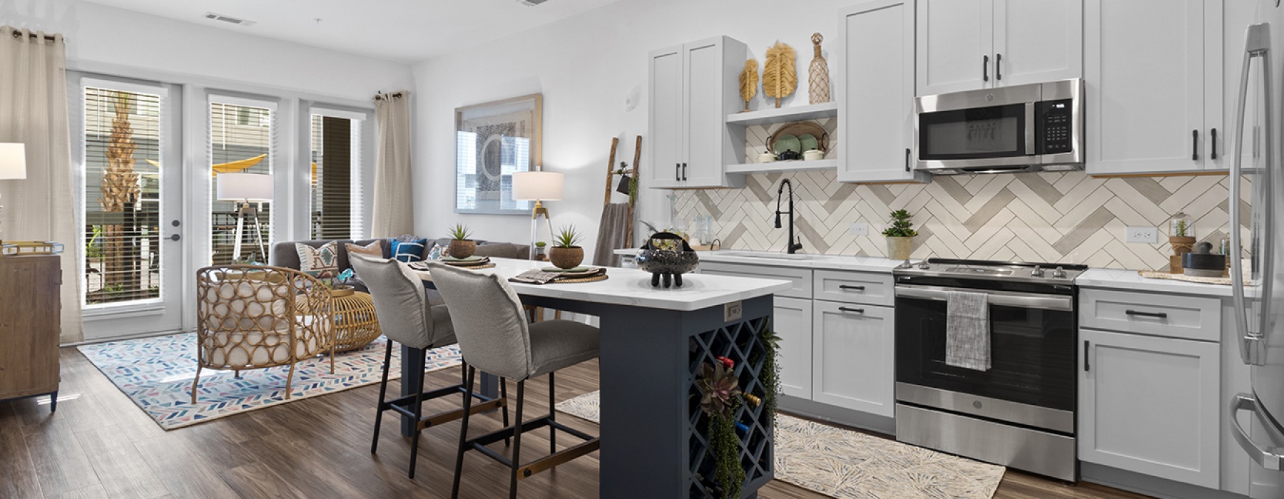 kitchen with white cabinets and island with bar chairs