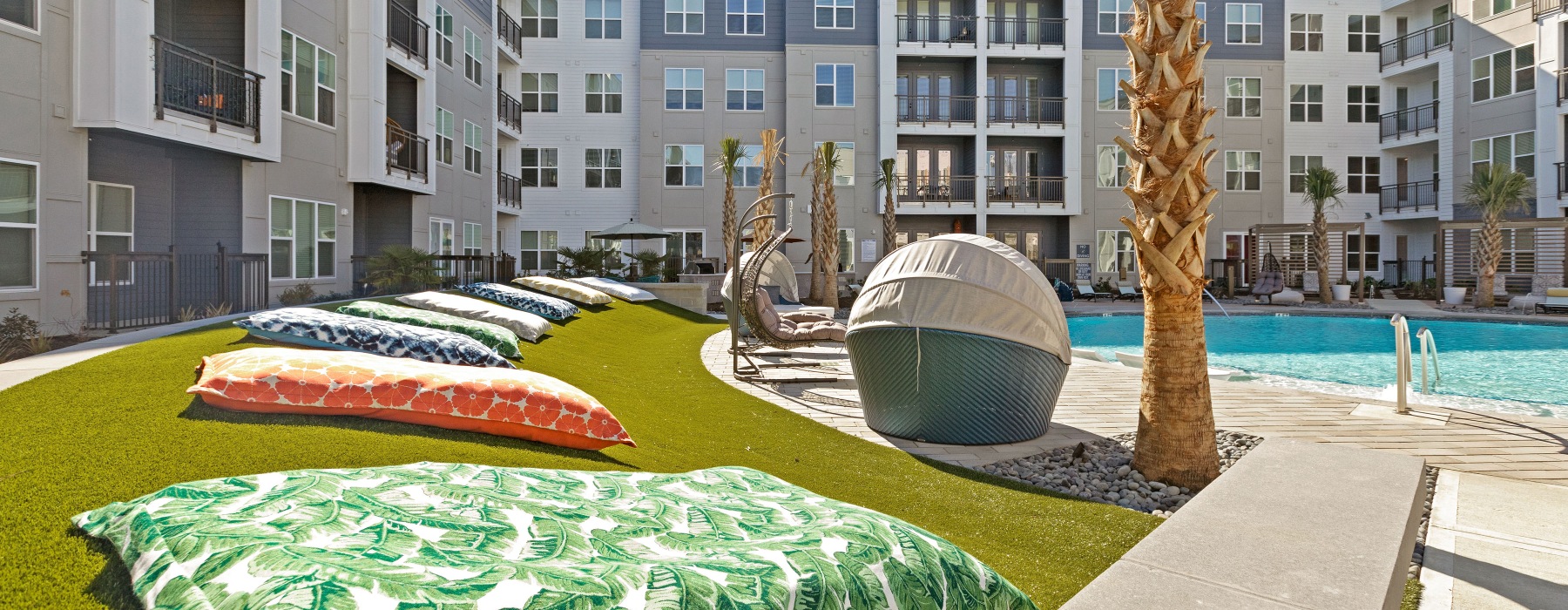 Lawn with large cushions by pool