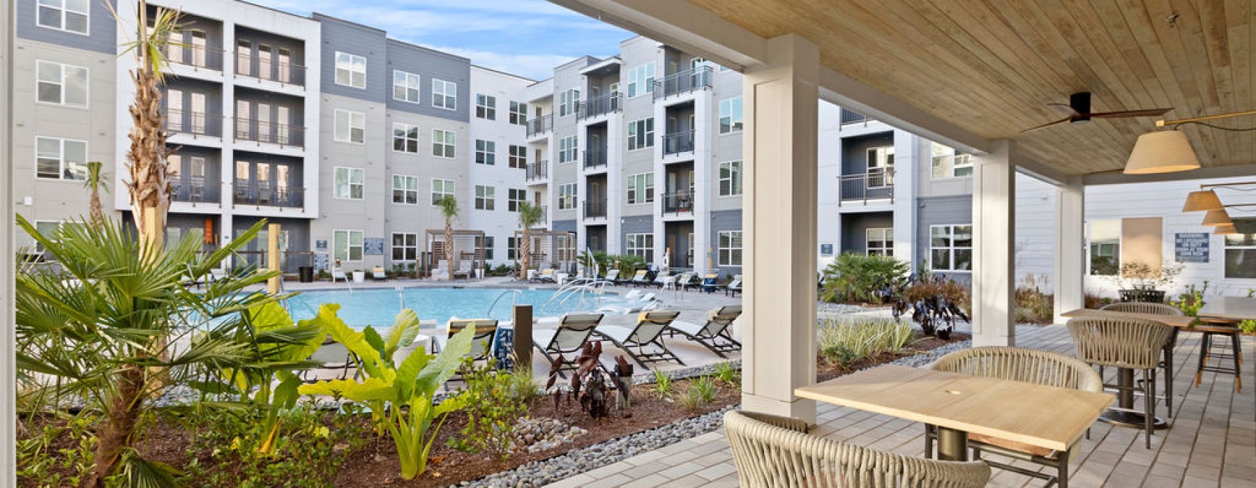 dining tables under shade near the pool